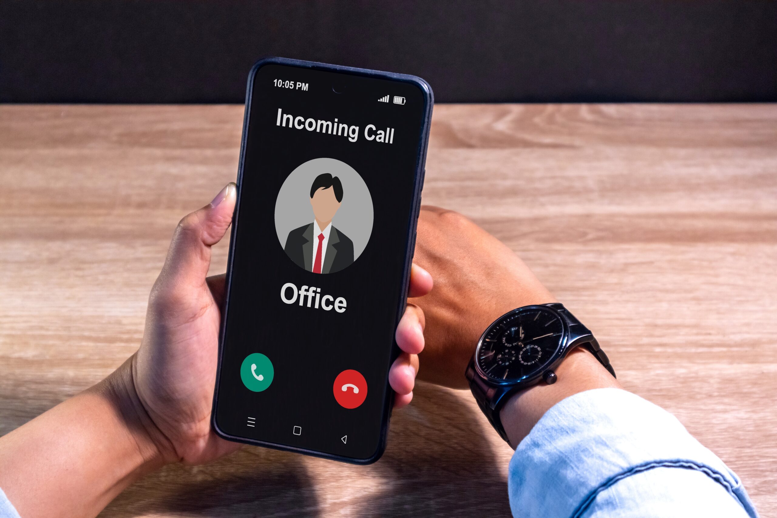 Hand,Holding,A,Smartphone,With,Incoming,Call,From,Office,At Tax time with wooden alphabet blocks, red alarm clock, calculator and pen on 1040 tax form background