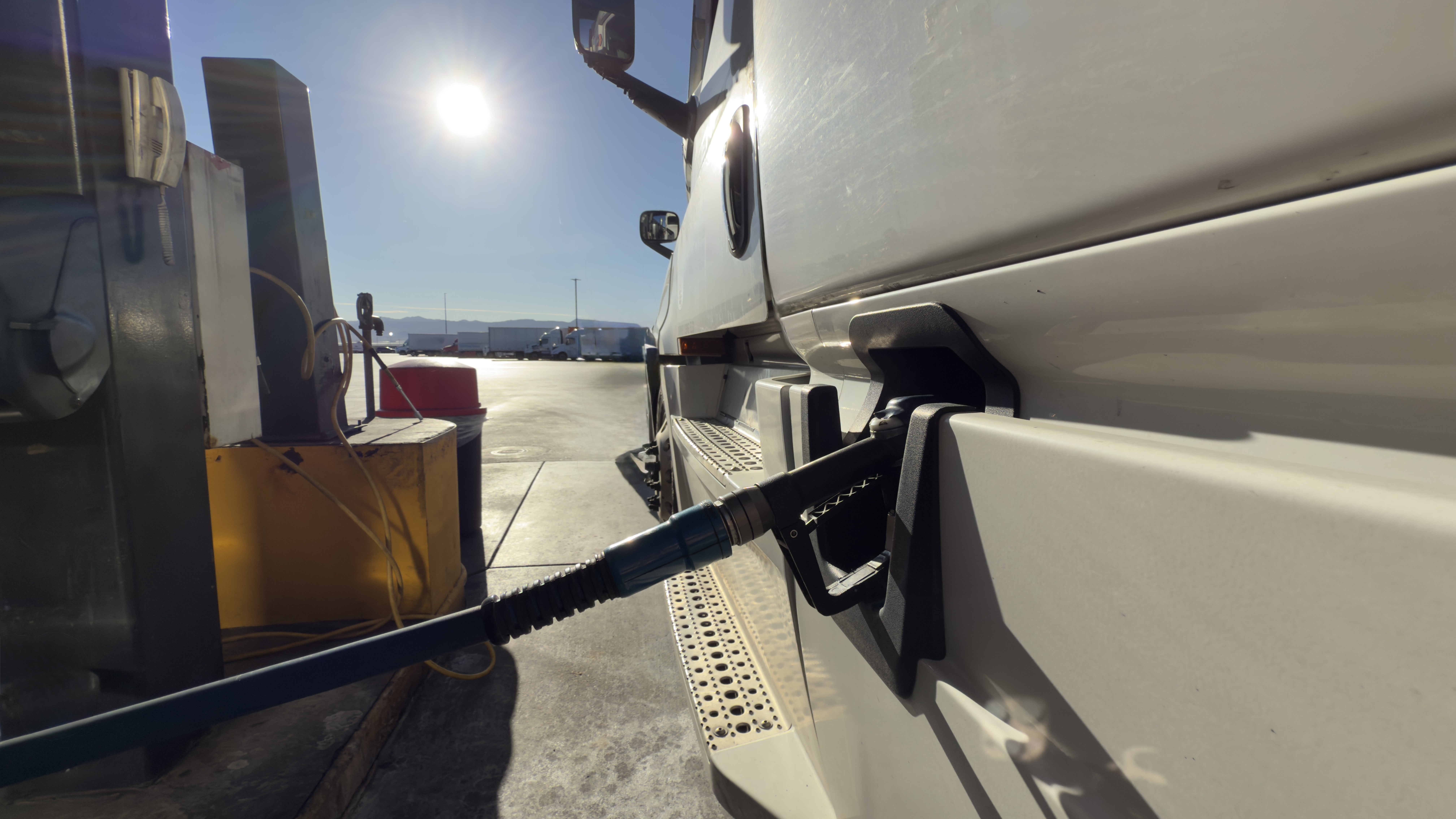 ?,Fueling,The,Journey:,Heavy-duty,Truck,Refueling,At,Gas,Station. Tax time with wooden alphabet blocks, red alarm clock, calculator and pen on 1040 tax form background